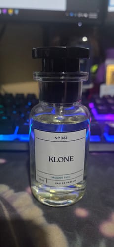 Customer's Klone No 364 fragrance bottle with a clear, cylindrical design standing on a dark surface.