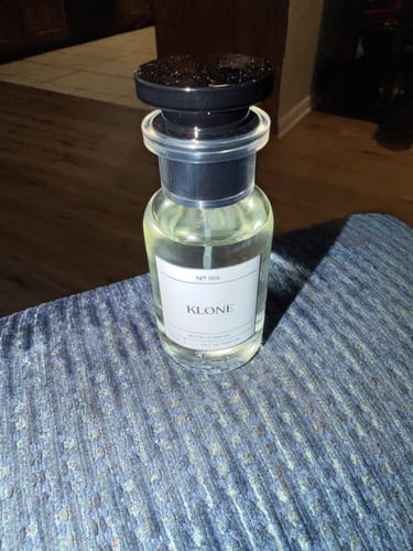 Customer's Royal Aventus fragrance bottle on a blue textured surface