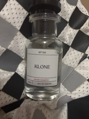 Customer's Klone Scent Collection perfume bottle, sitting on a black and white checkered fabric.
