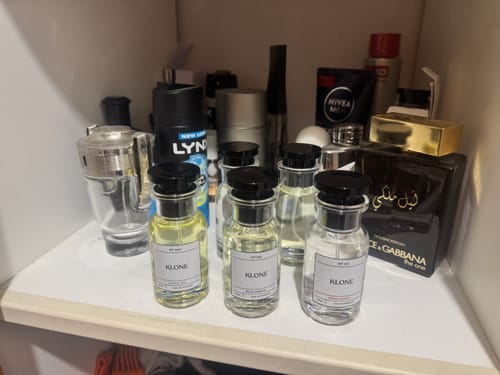 Customer's Klone Scent perfume bottles arranged on a white shelf among other toiletry products.