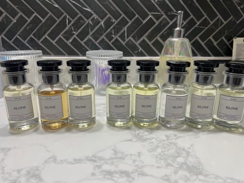 Customer's collection of eight Delila fragrance bottles lined up on a marble countertop.